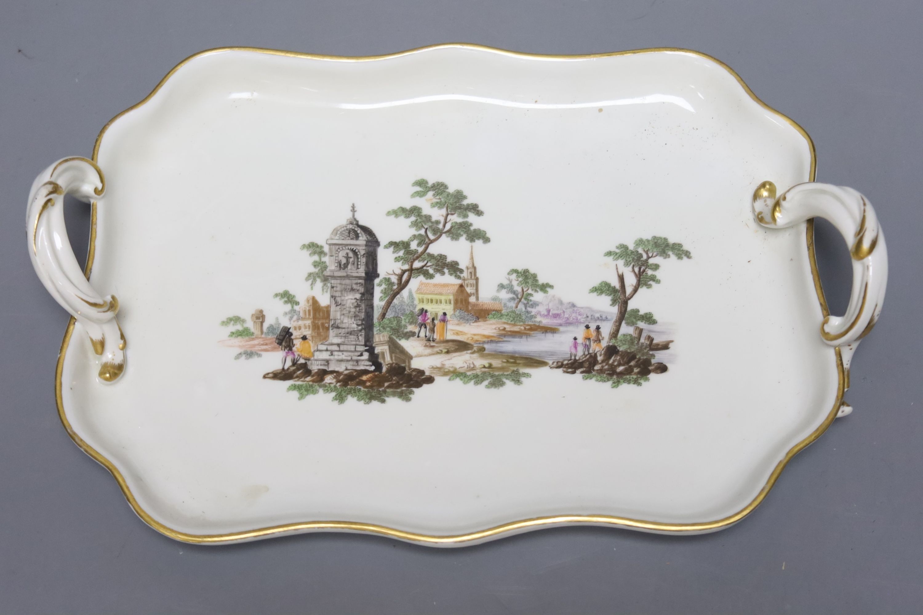 Two 18th century Vienna porcelain trays and a seated figure, largest tray 16cm